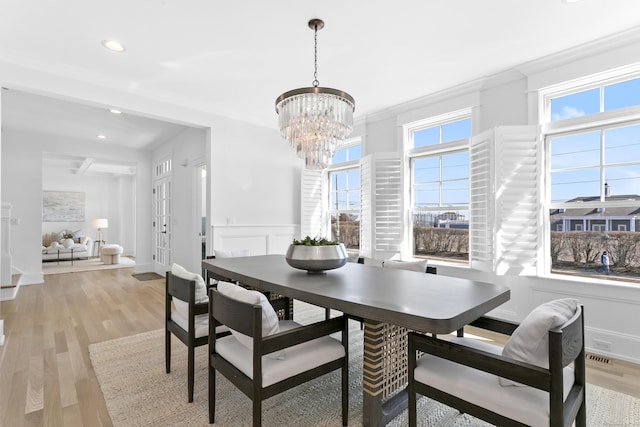 40 Fairfield Beach Rd, Fairfield, CT 06824 - dining area featuring a chandelier, recessed lighting, light wood-style flooring, crown molding, and a decorative wall