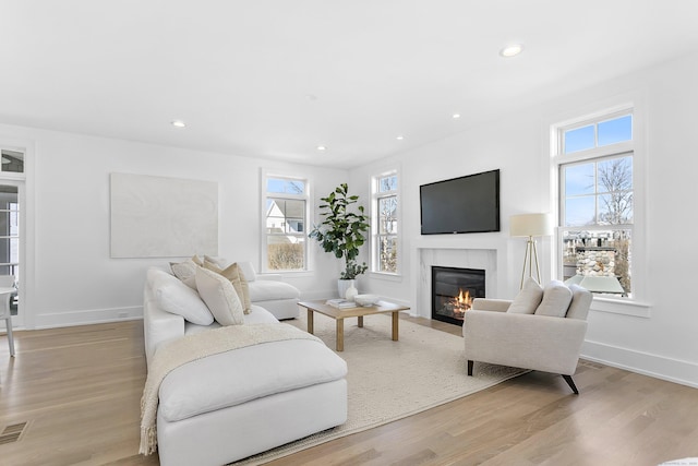 40 Fairfield Beach Rd, Fairfield, CT 06824 - living area featuring a glass covered fireplace, light wood finished floors, recessed lighting, and baseboards