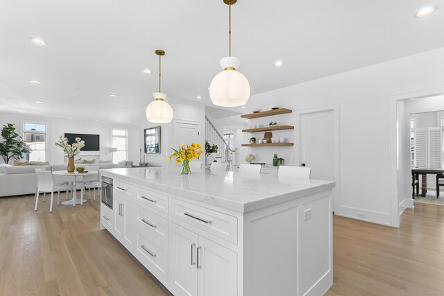 40 Fairfield Beach Rd, Fairfield, CT 06824 - kitchen with light wood finished floors, white cabinetry, open shelves, a kitchen island, and pendant lighting