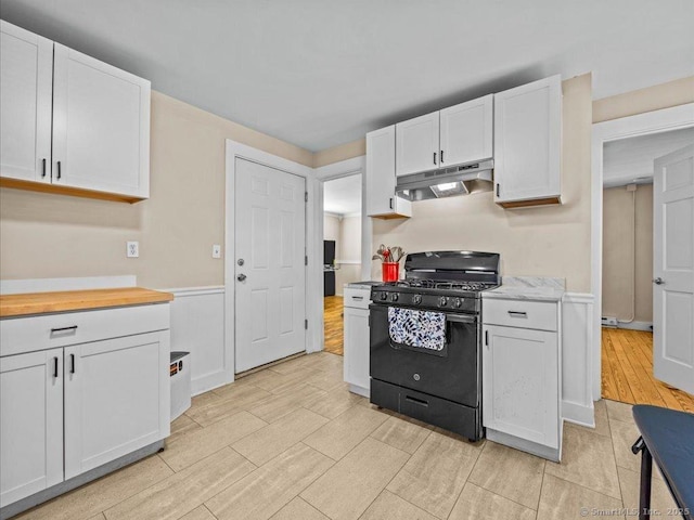 kitchen featuring black range with gas cooktop, wood finish floors, white cabinetry, and under cabinet range hood