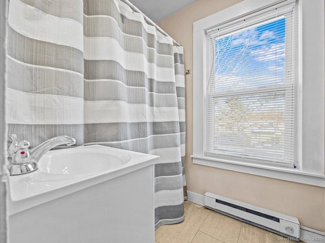 full bathroom featuring a baseboard radiator, a sink, baseboards, and tile patterned floors