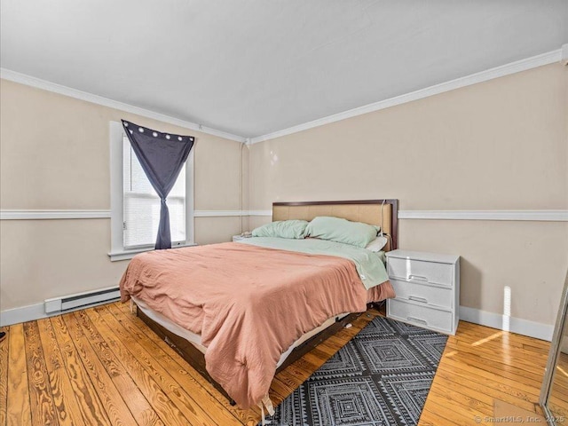 bedroom with ornamental molding, baseboard heating, wood finished floors, and baseboards