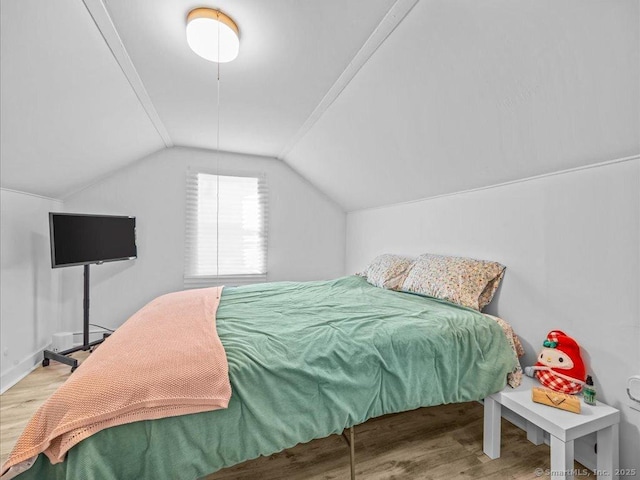 bedroom with lofted ceiling and wood finished floors