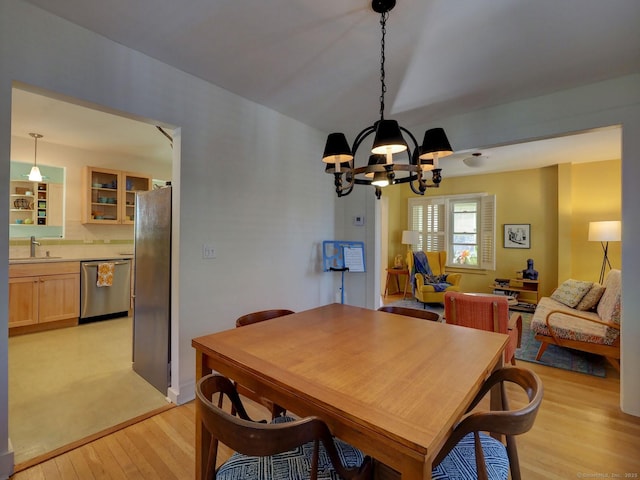 dining room featuring light wood-type flooring and an inviting chandelier