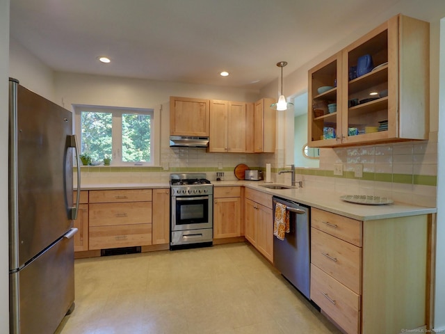 kitchen featuring stainless steel appliances, light countertops, and light brown cabinetry