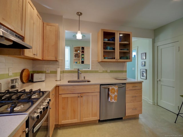 kitchen with appliances with stainless steel finishes, light countertops, and a sink