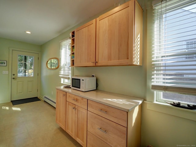 kitchen featuring white microwave, light brown cabinets, light countertops, baseboard heating, and open shelves