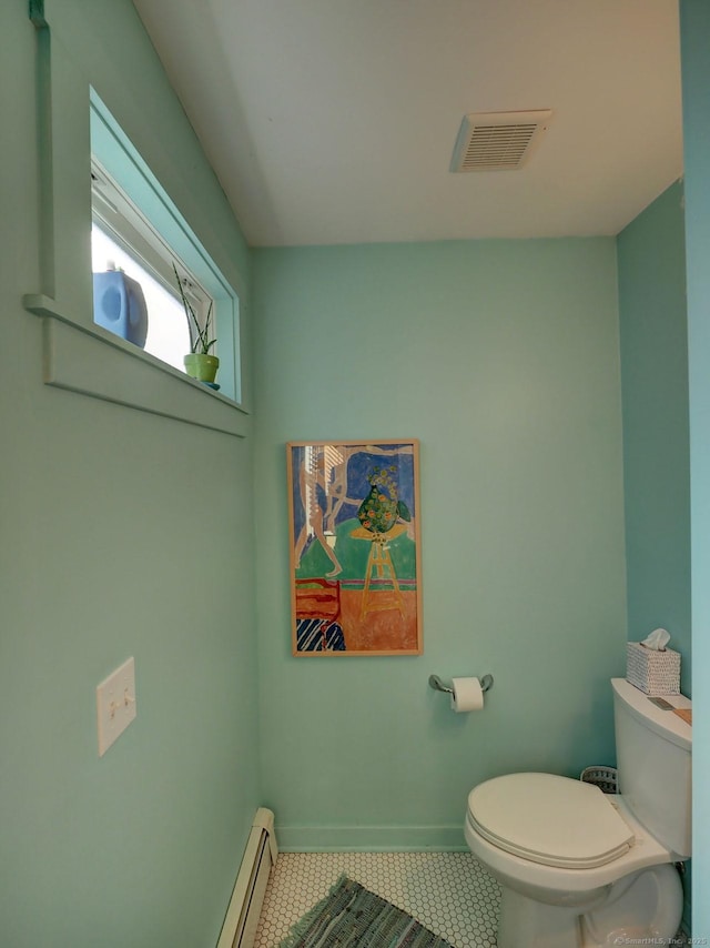 bathroom with visible vents, baseboard heating, toilet, baseboards, and tile patterned floors