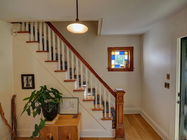 stairway featuring baseboards and wood finished floors