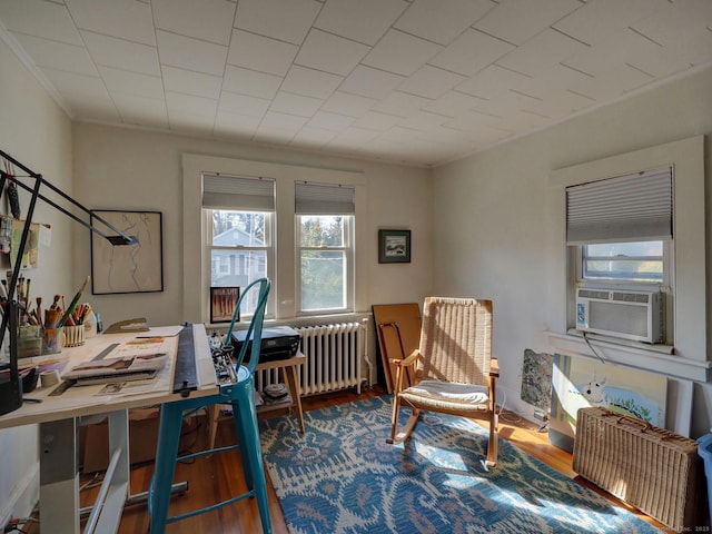 home office featuring radiator heating unit, cooling unit, and wood finished floors