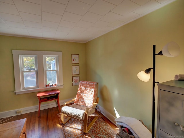 living area featuring baseboards and hardwood / wood-style floors