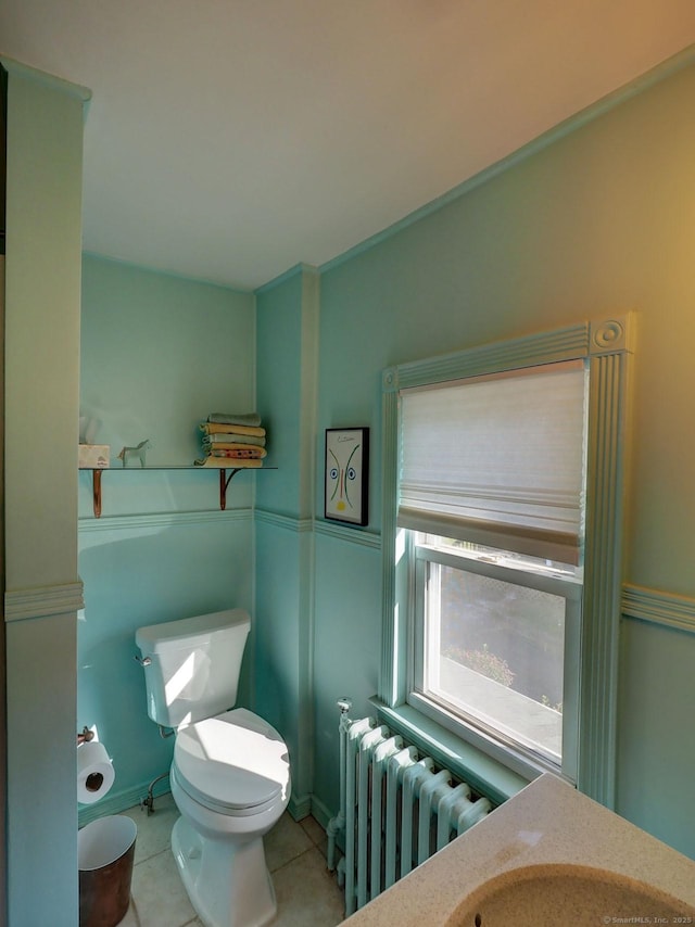 half bathroom featuring tile patterned floors, toilet, and radiator