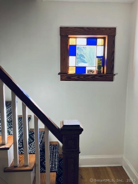 staircase featuring baseboards and wood finished floors