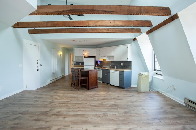 kitchen featuring a center island, light countertops, hanging light fixtures, white cabinetry, and white appliances