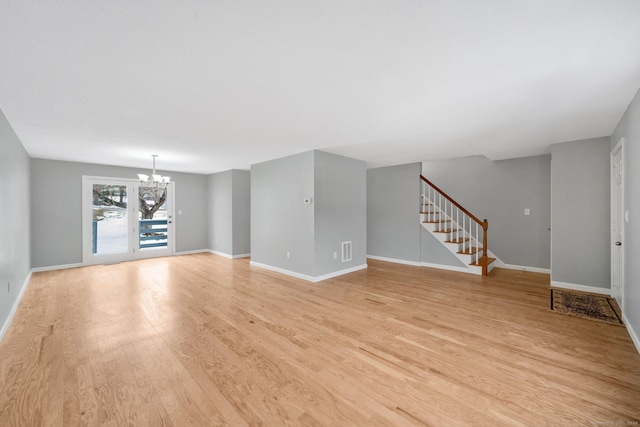 unfurnished living room featuring a notable chandelier, visible vents, stairway, light wood-type flooring, and baseboards