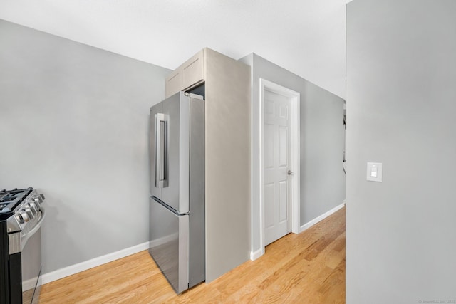 kitchen with baseboards, appliances with stainless steel finishes, and wood finished floors