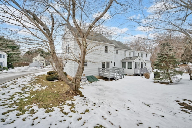 view of snowy exterior featuring a deck