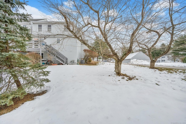 yard covered in snow featuring stairway