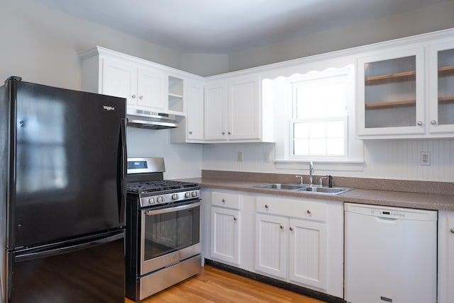 kitchen with freestanding refrigerator, stainless steel range with gas stovetop, a sink, dishwasher, and under cabinet range hood