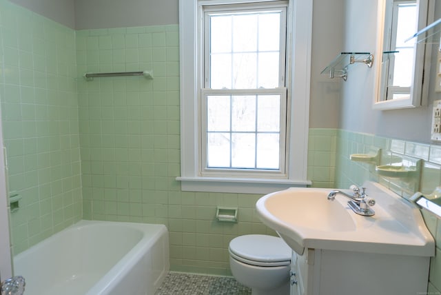 full bathroom with toilet, wainscoting, tile patterned flooring, and tile walls