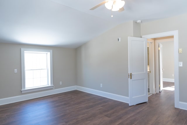 unfurnished room with vaulted ceiling, dark wood finished floors, a ceiling fan, and baseboards