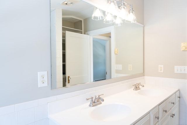 full bath with double vanity, visible vents, and a sink