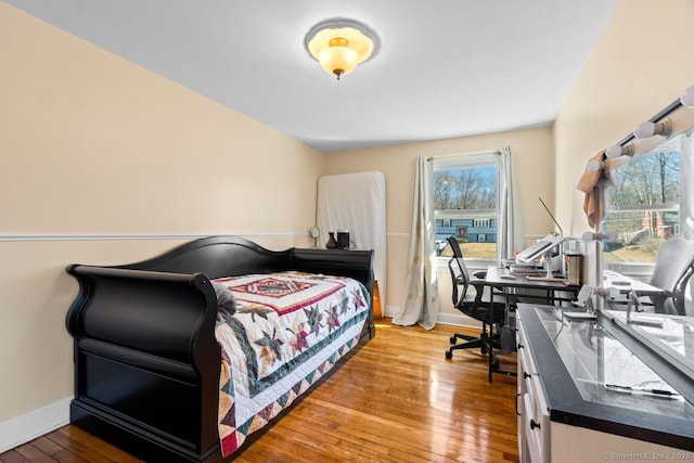 bedroom with wood-type flooring and baseboards