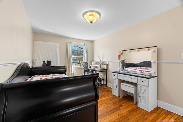 bedroom with hardwood / wood-style flooring and baseboards