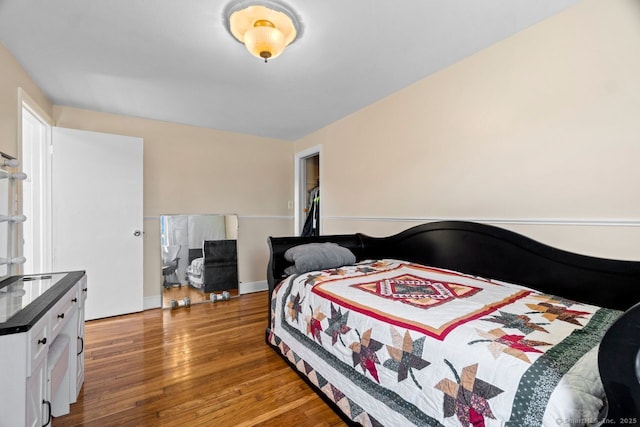 bedroom featuring wood finished floors and baseboards