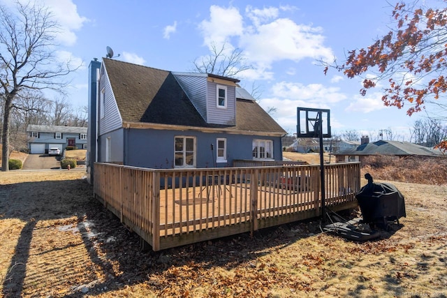 rear view of property with roof with shingles and a wooden deck