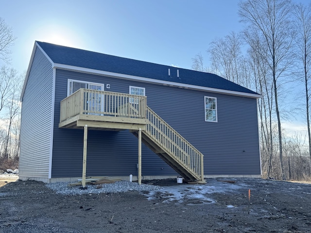 back of house with stairs and a shingled roof