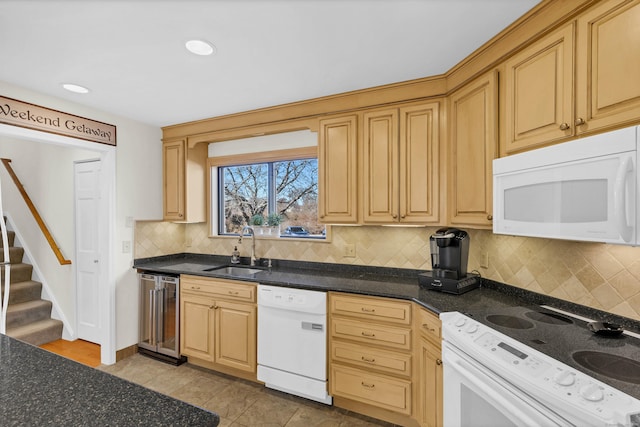 kitchen with backsplash, a sink, beverage cooler, white appliances, and baseboards