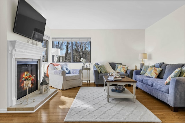 living room featuring a tile fireplace and wood finished floors