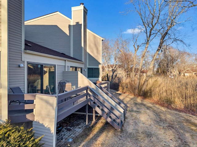 exterior space featuring a chimney and a wooden deck