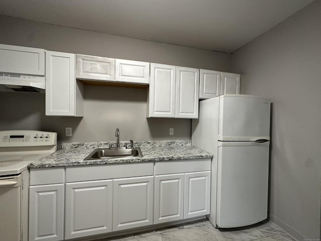 kitchen with white appliances, white cabinetry, a sink, and under cabinet range hood