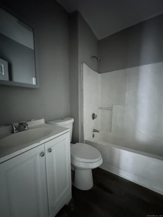 full bath with  shower combination, vanity, toilet, and wood finished floors