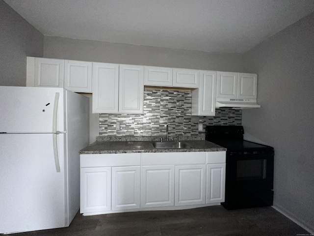 kitchen with under cabinet range hood, dark countertops, freestanding refrigerator, and black electric range oven