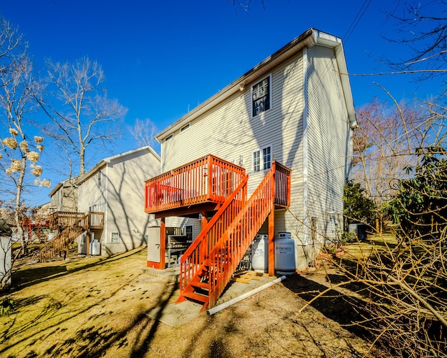 rear view of house with stairway and a wooden deck