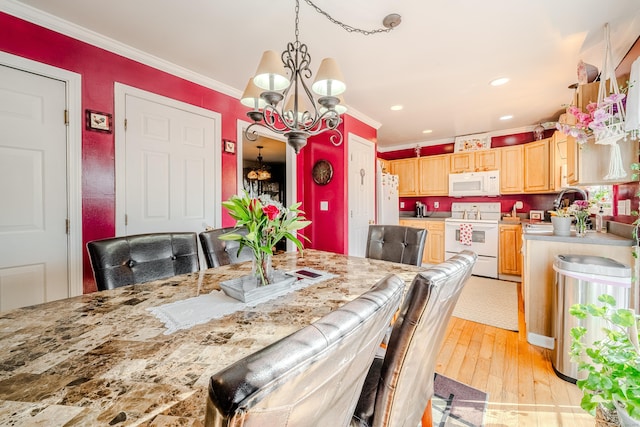 dining area with a chandelier, light wood finished floors, recessed lighting, and crown molding