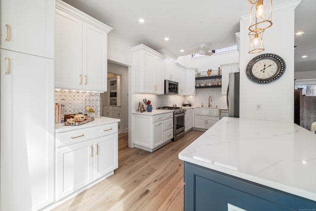 kitchen featuring stainless steel appliances, light wood-style floors, white cabinets, decorative backsplash, and open shelves