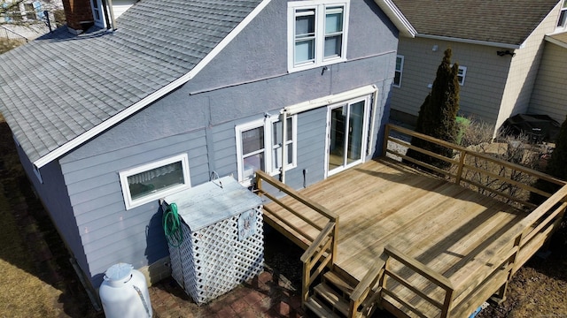 back of property featuring a shingled roof and a wooden deck