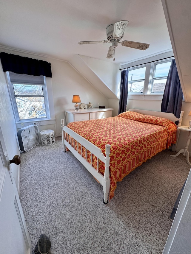 carpeted bedroom featuring vaulted ceiling, multiple windows, and ceiling fan