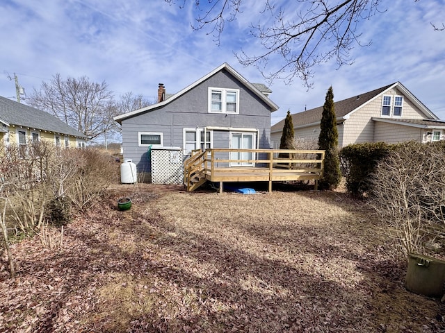 rear view of property featuring a chimney and a wooden deck