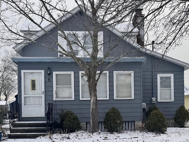 bungalow-style house featuring entry steps and a chimney