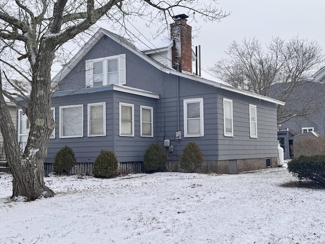 view of snowy exterior featuring a chimney