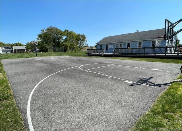 view of basketball court with community basketball court and a lawn