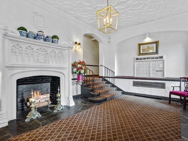 sitting room with a chandelier, a fireplace with flush hearth, ornamental molding, wainscoting, and mail area