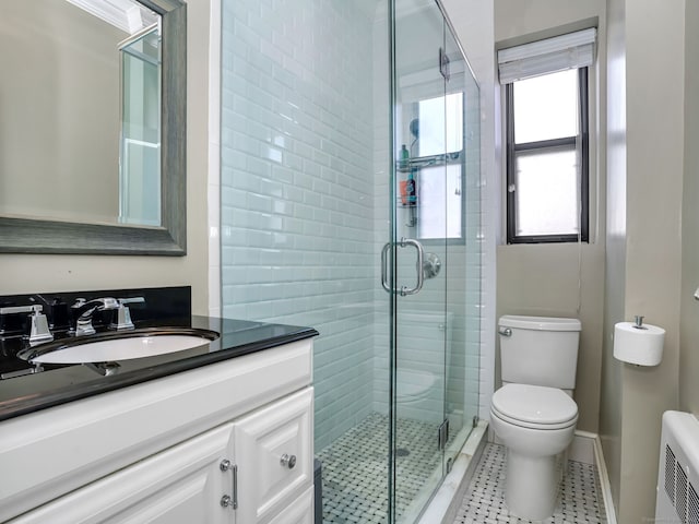 full bathroom featuring toilet, vanity, baseboards, a shower stall, and radiator