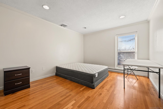 bedroom with baseboards, visible vents, light wood-style flooring, a textured ceiling, and crown molding