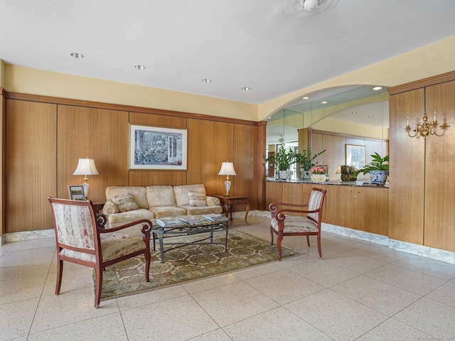 living room featuring light speckled floor, recessed lighting, and wooden walls